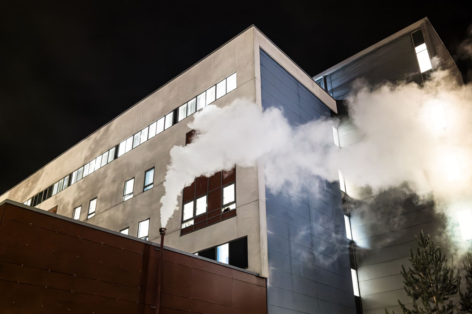 Image of a hospital with steam coming from the HVAC system.